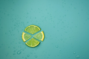 Slices of fresh lime and lemon on a blue background with water drops. Citrus background. 