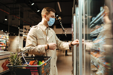 Man shopping in supermarket in mask during quarantine