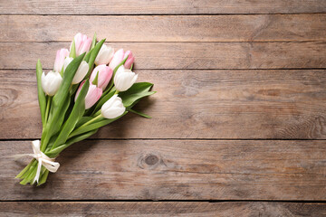 Beautiful pink spring tulips on wooden background, top view. Space for text