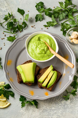 toasted rye bread with sliced avocado and herbs, healthy concept, vertical format