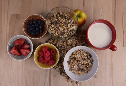 Healthy breakfast with muesli and fruits on the table top view stock images. Bowl of muesli with milk and fruits on a wooden background stock photo