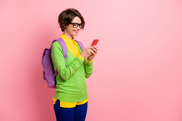 Photo of lady dressed yellow shirt glasses backpack holding looking modern device empty space isolated pink color background