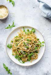 Whole wheat pasta spaghetti with green peas and avocado on white plate. Vegan healthy lunch or dinner. flat lay. vertical image