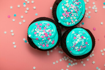 Sweet food for birthday, Valentine's day, children's holiday. Cupcakes with turquoise icing and sugar sprinkles in the form of pink hearts and stars. Top view