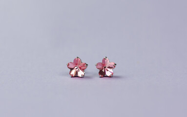 Pink flowers crystal earrings on purple background 