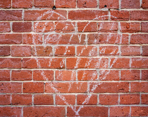Background of a chalk drawn heart on a brick wall
