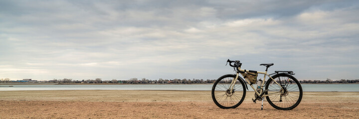 spring biking, touring or commuting - bicycle on a lake beach, Boyd Lake State Park in northern Colorado, panoramic banner