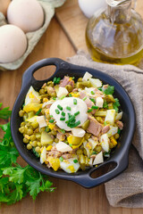 Fish salad with tuna, pickles, green peas and eggs