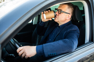 Elderly man experience self-driving smart car and has a cup of coffee