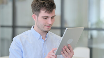Portrait of Young Man using Digital Tablet
