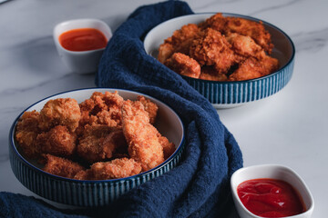 Crispy Chicken Pops Korean Style with Ketchup Chili sauce. Dark tone.