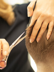 the barber at work. the master cuts his hair with scissors