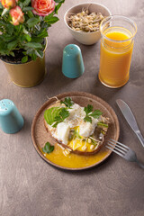 Light summer breakfast - sandwich with avocado, cottage cheese, sprouted beans and poached egg with orange juice on the table