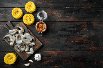 Traditional Italian dish. pasta with pesto ricotta parmesan and grilled seafood ingredients, on old dark  wooden table , top view flat lay, with copy space for text