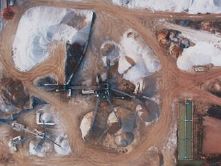 Aerial view of a quarry with big machinery at work while processing different gravel size in Candia Lomellina, Lombardy, Italy.