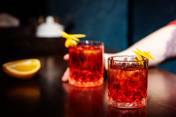 Negroni Cocktail with orange and ice. Homemade Classic Negroni cocktail and ingredients on wooden table, copy space.