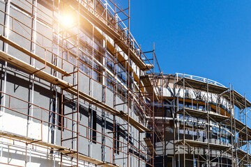 Extensive scaffolding providing platforms for work in progress on a new apartment block,Tall...