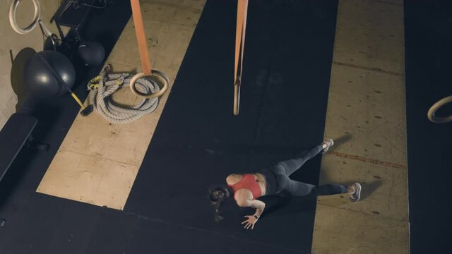 Young woman practicing burpee in gym. Slow motion