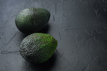 Ripe pair of green avocado, on black background with copy space for text