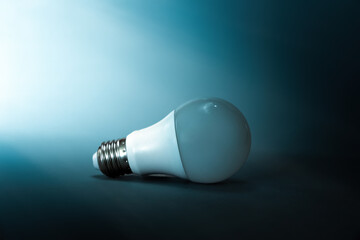 A light bulb on a dark blue background. Copy space. The concept of creativity, crisis, and ideas....