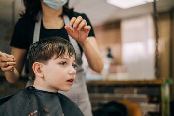 Haircut for little kid boy, professional barber doing haircut. Hairdress for children