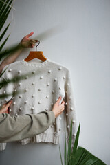 white knitted sweater holding multiple hands