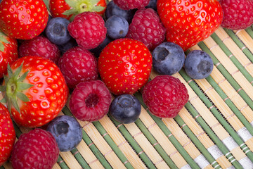 Strawberries, blueberries, raspberries scattered top view