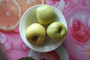 Three green apples in a plate