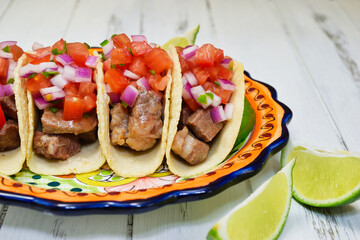 メキシコ料理の美味しい牛肉のタコス　サルサ・メヒカーナとライムを添えて　コピースペースあり　Delicious Mexican Beef Tacos served with Salsa Mexicana and lime, copy space available