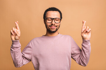 Concentrated relaxed african american black man standing with closed eyes, having relaxation while...