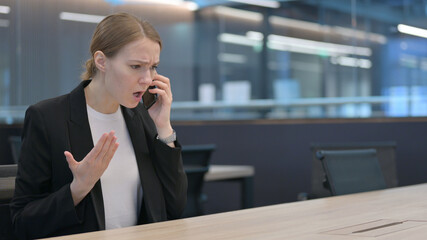 Angry Businesswoman Talking on Smartphone at Work 