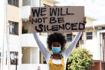 Portrait of mixed race woman wearing a face mask with writing