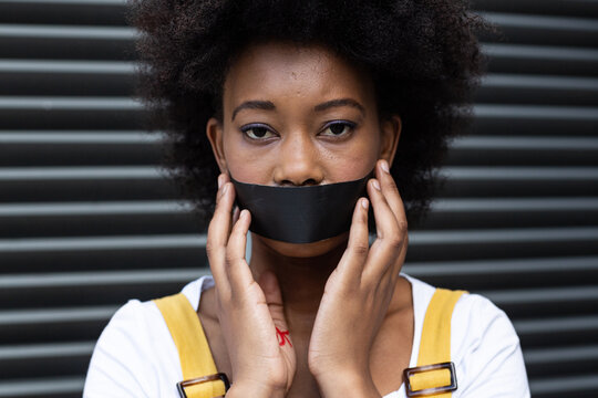 Portrait of mixed race woman having black tape on mouth