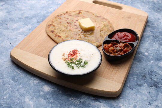 Traditional Indian food Aloo paratha or potato stuffed flat bread. served with pickle  tomato ketchup and curd, 