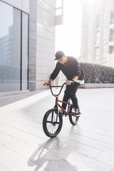 Young guy riding bmx backlight