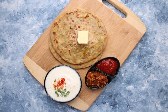 Traditional Indian food Aloo paratha or potato stuffed flat bread. served with pickle  tomato ketchup and curd, 