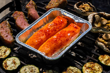 veal meat, salmon and zucchini on garden grill with charcoal