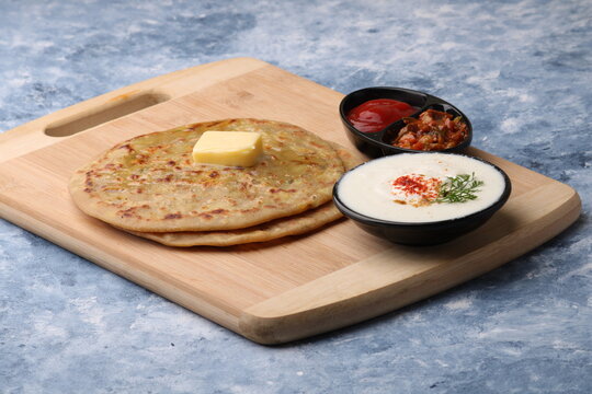 Traditional Indian food Aloo paratha or potato stuffed flat bread. served with pickle  tomato ketchup and curd, 