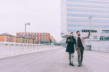 Two young businessman tablet outdoor walking