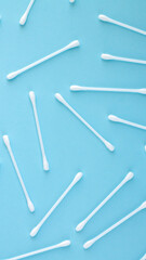 Pattern of white plastic cotton swabs top view on blue background
