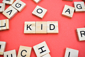 Kid word on wooden cube blocks on with letters all around. Concept