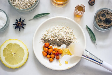 Home cosmetic mask for face skin from natural ingredients of fresh berries, oatmeal, honey, essential oils. Ingredients for making handmade natural cosmetics, flat lay, copy space 