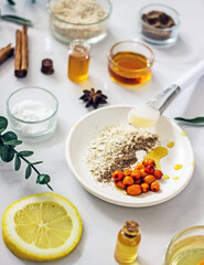 Home cosmetic mask for face skin from natural ingredients of fresh berries, oatmeal, honey, essential oils. Ingredients for making handmade natural cosmetics, flat lay, copy space 