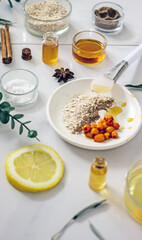 Home cosmetic mask for face skin from natural ingredients of fresh berries, oatmeal, honey, essential oils. Ingredients for making handmade natural cosmetics, flat lay, copy space 