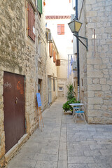 Fototapeta na wymiar A small street in the medieval quarter of Trogir, an old Croatian town.