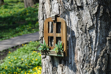 original homemade bird feeder on the trunk of a large tree in the park