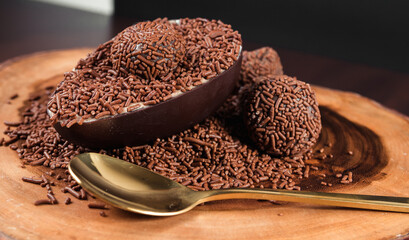 Chocolate Easter Egg filled with brigadeiro (brigadier), Goumert egg chocolate tradition in Brazil. Wood Background