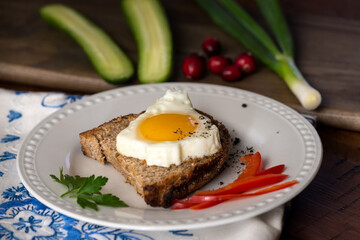 Morning breakfast toast with egg in the shape of a Christmas tree, homemade sourdough bread, parsley, cucumbers, and green onions.