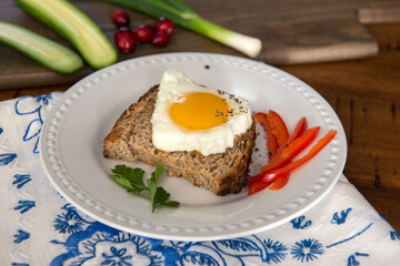Morning breakfast toast with egg in the shape of a Christmas tree, homemade sourdough bread, parsley, cucumbers, and green onions.