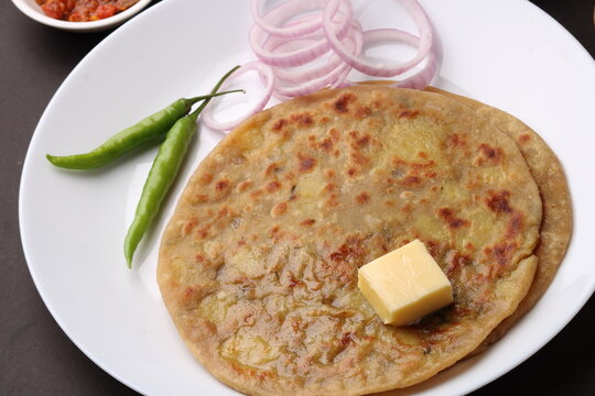 Traditional Indian food Aloo paratha or potato stuffed flat bread. served with pickle  tomato ketchup and curd, butter, onion, chili.